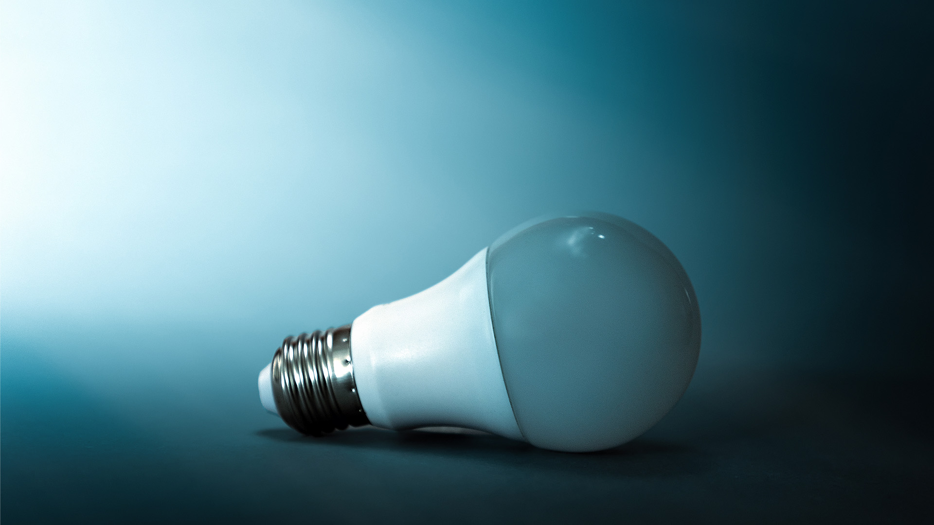 A light bulb on a dark blue background. Copy space. The concept of creativity, crisis, and ideas.